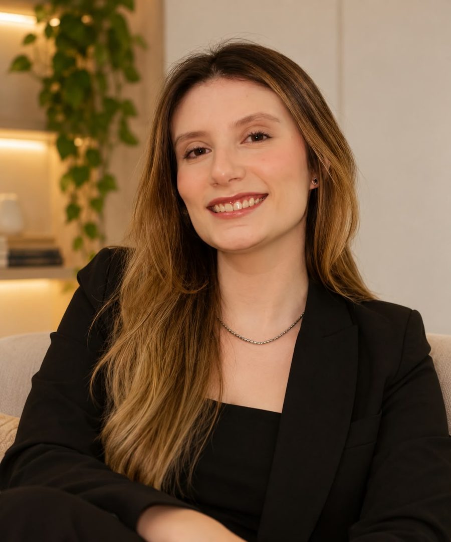 Clara Abussafi sorrindo, sentada em uma poltrona no consultório